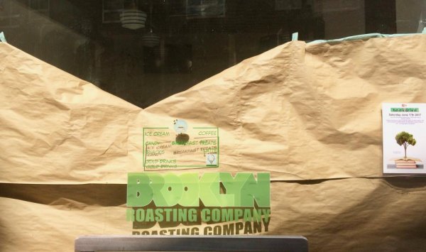 Roosevelt Island, August 2017, History Meets Future With reminders of the popular Main Street Sweets still on the windows, Bubble Tea Emporium has begun building inside. Step up on the bench to see more.